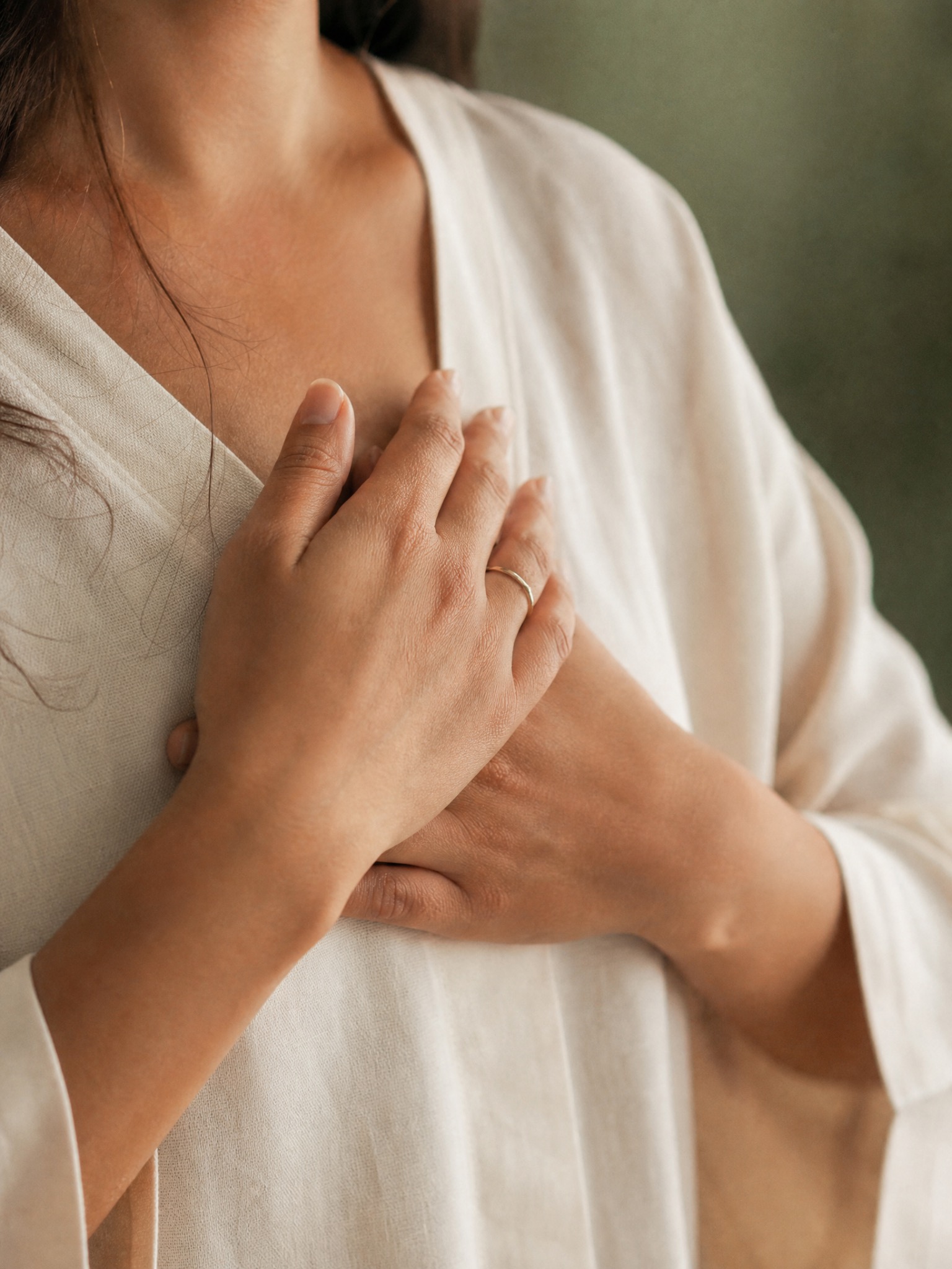 Woman resting both hands over her heart during a gentle body-awareness practice